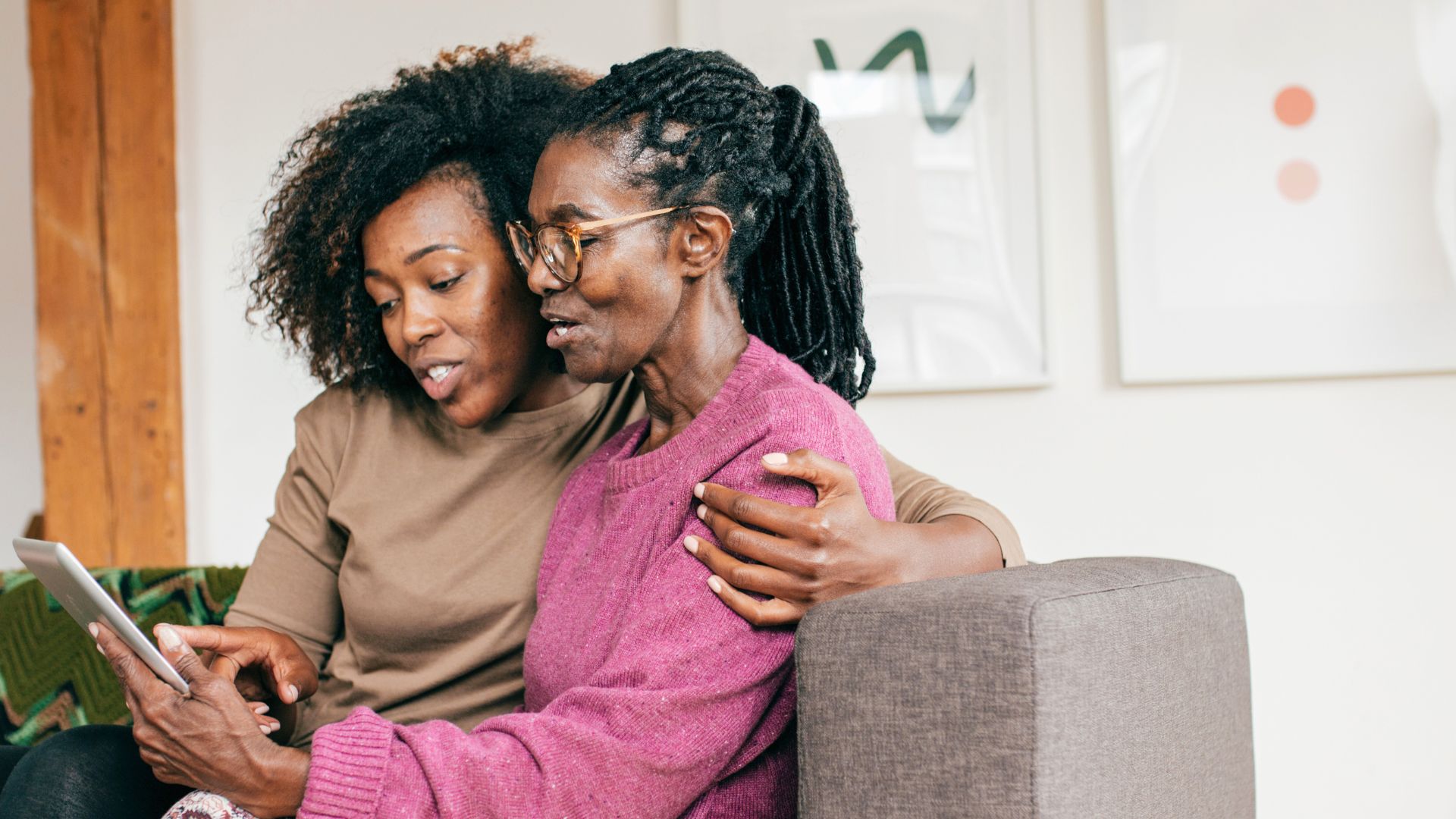 A woman is helping another woman with z codes for social determinants of health on a tablet.