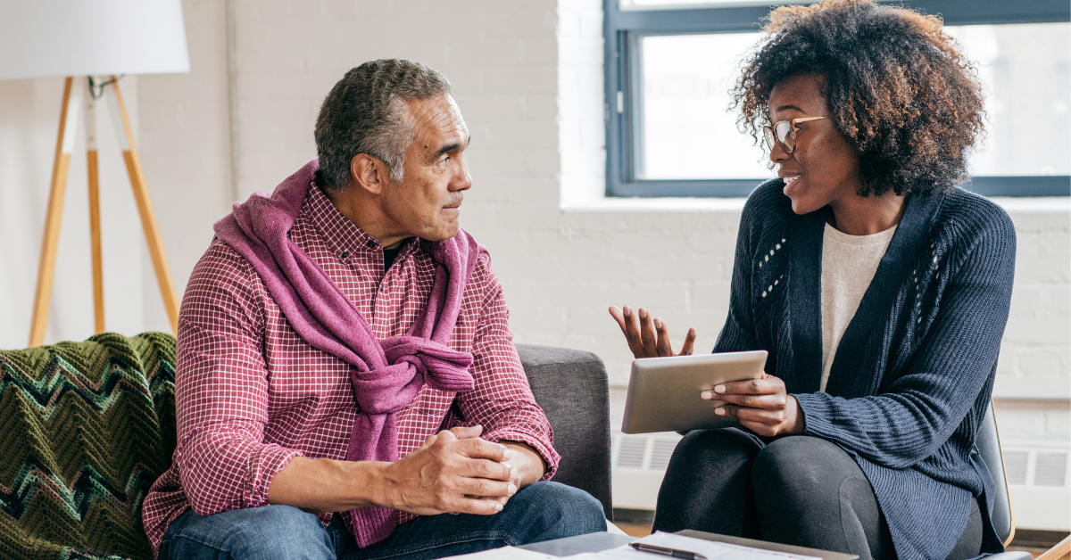 Woman and man sitting in a residential mental health facility discussing notes and care plans