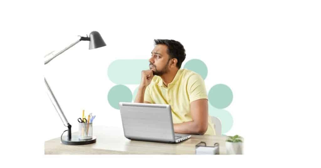 A man sits a laptop at a desk and worries about Medicaid funding.